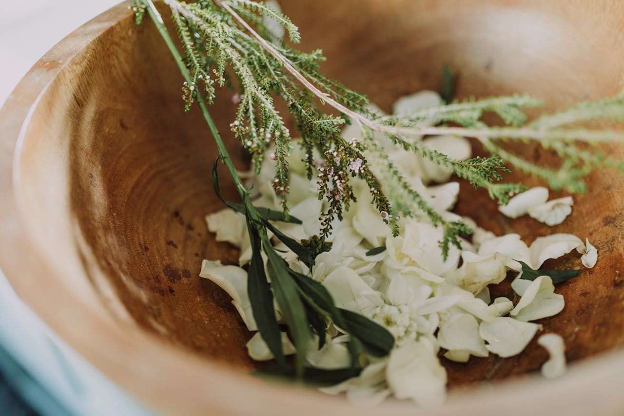 Services Wooden bowl filled with fresh herbs and flowers for aromatherapy and relaxation.